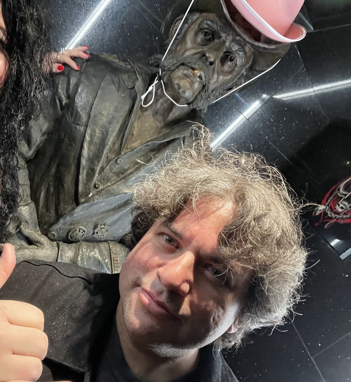 Yours truly in front of a statue of Lemmy Kilmeister (wearing a pink party hat) at the Sunset Room in Los Angeles